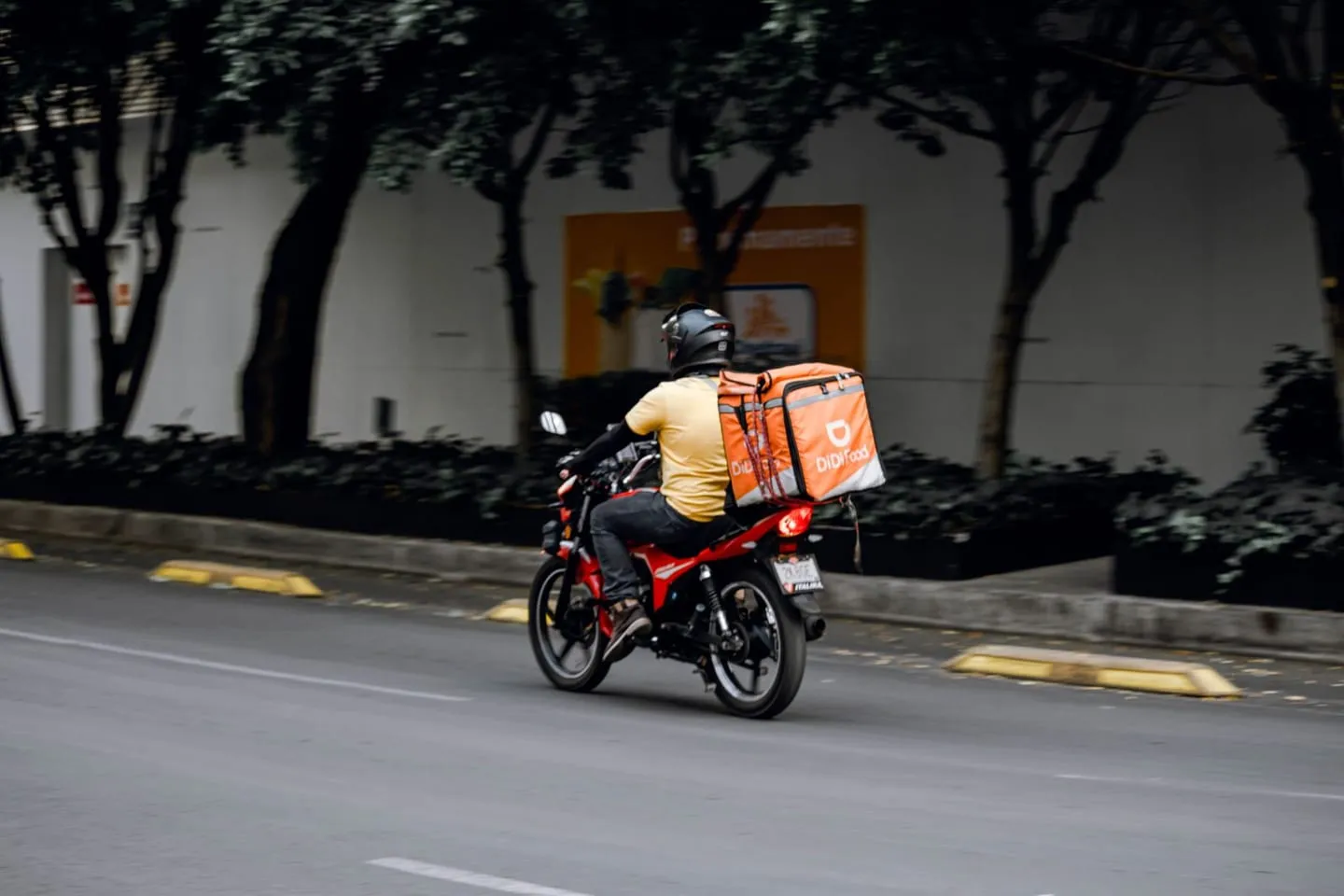 Şehirde motosikletle sipariş taşıyan bir kurye