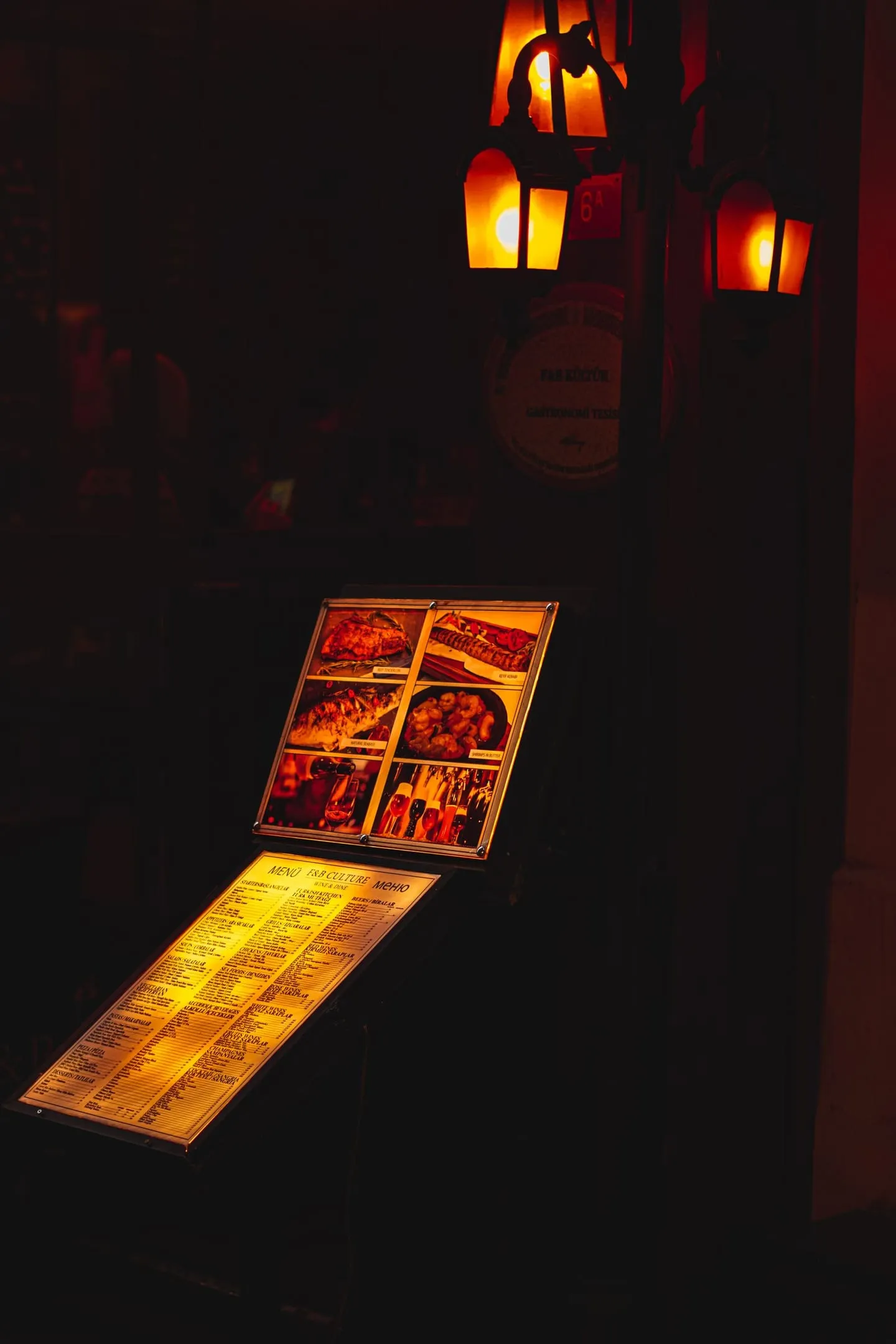 An illuminated menu displayed at the entrance of a restaurant