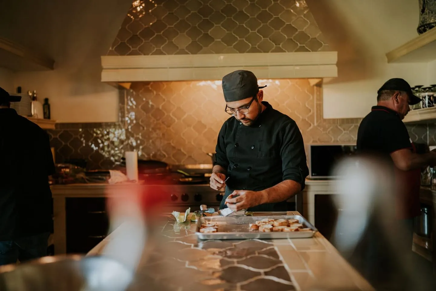 A chef plating a dish in a professional kitchen