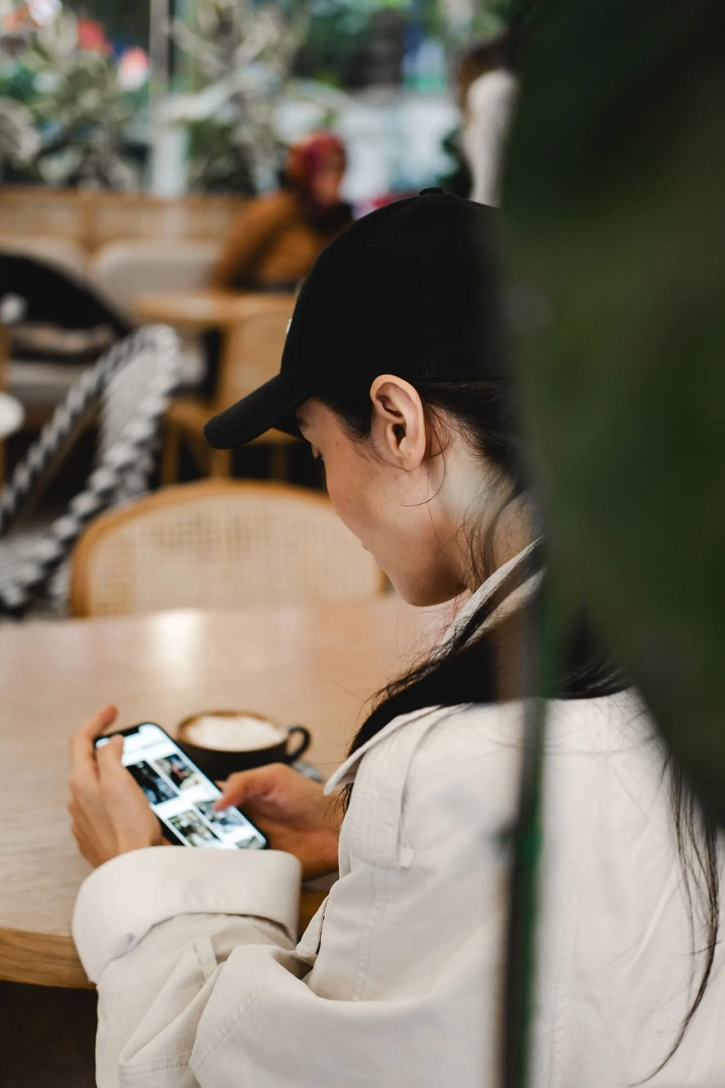 Restoranda kahve içerken telefonuna bakan kadın