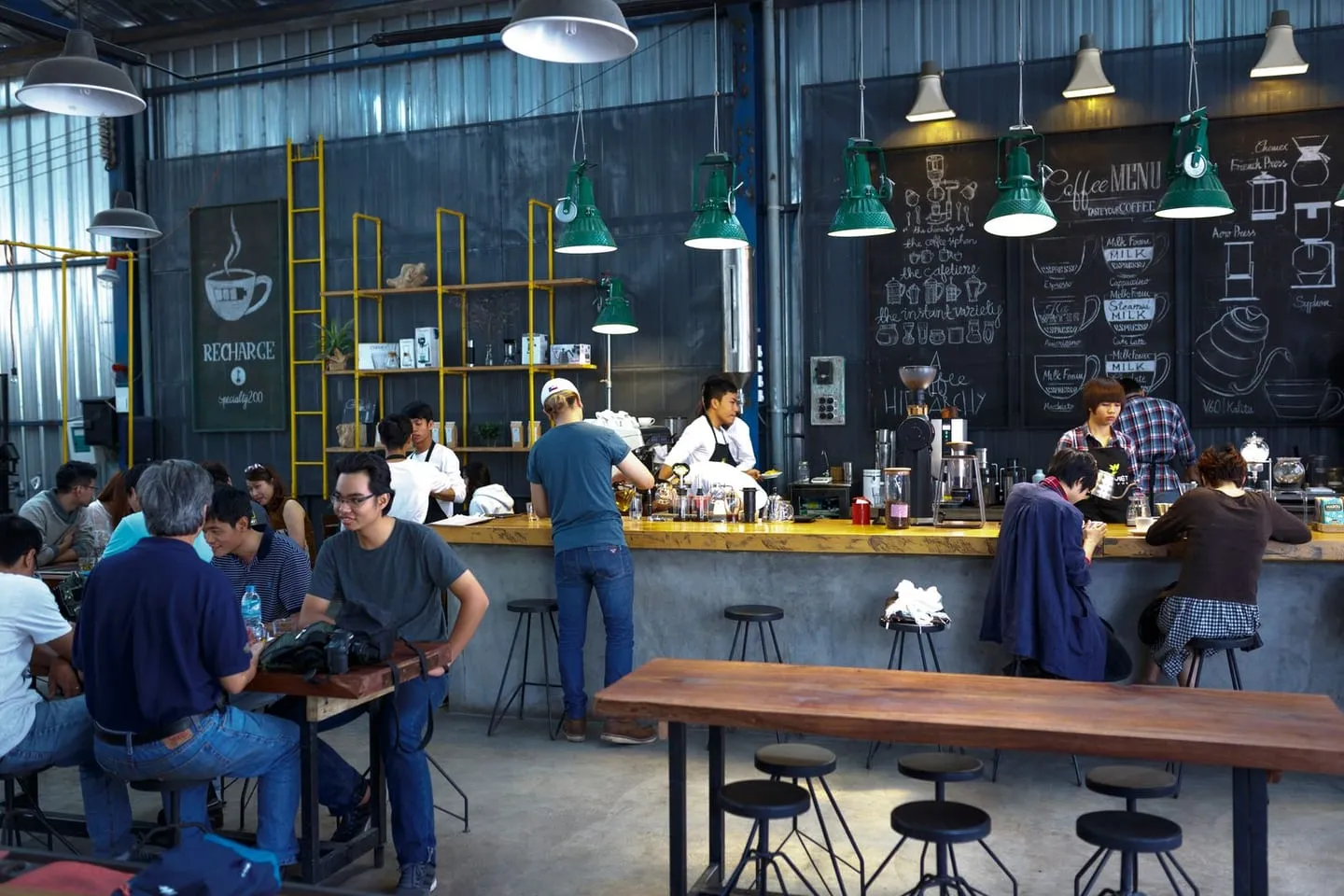 Suasana kedai kopi yang ramai dengan barista dan pengunjung