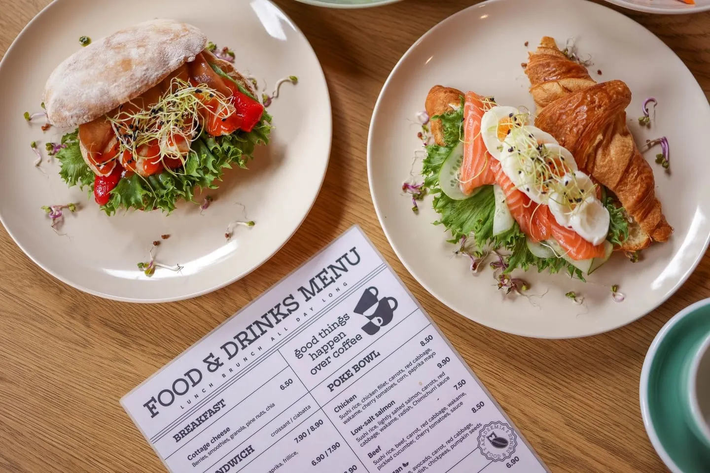 An overhead shot of plated food beside a restaurant menu