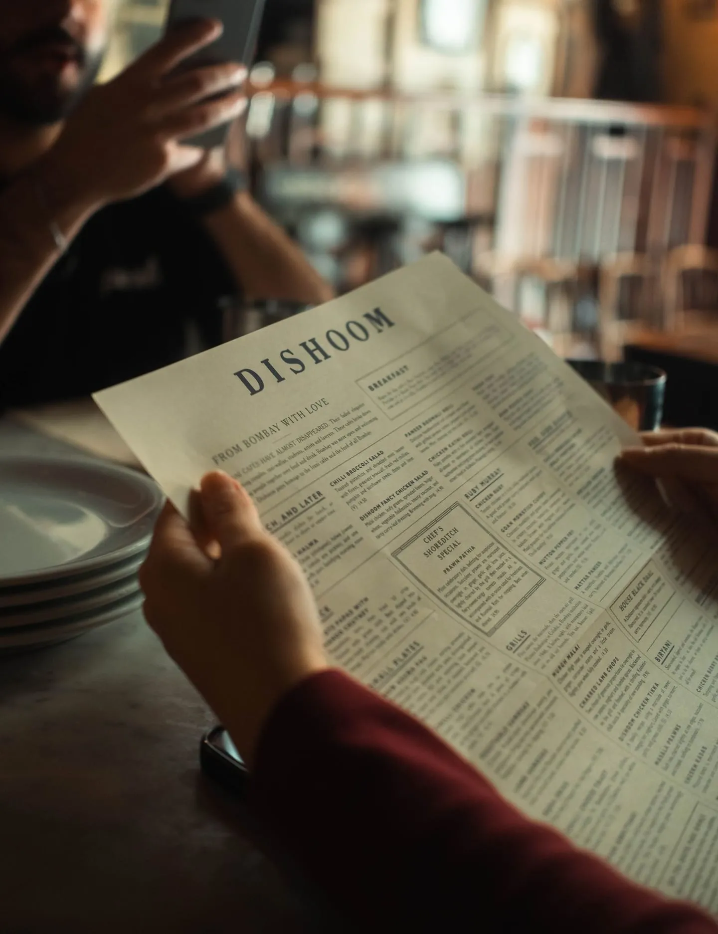 A customer reviewing a menu at a restaurant table