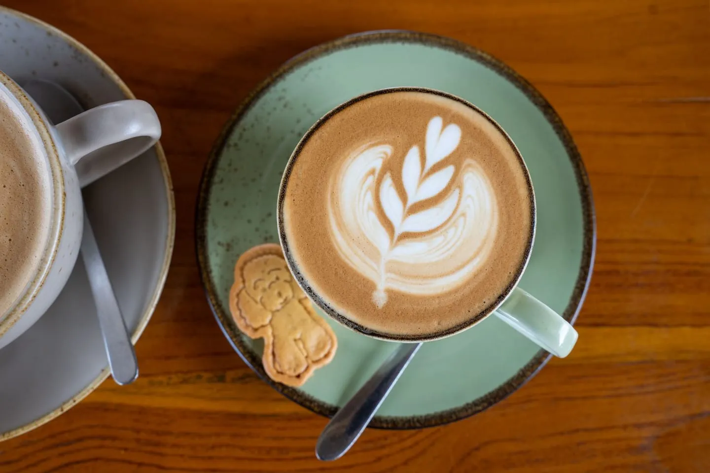 Latte dengan latte art dan kue di sebuah kafe di Bali