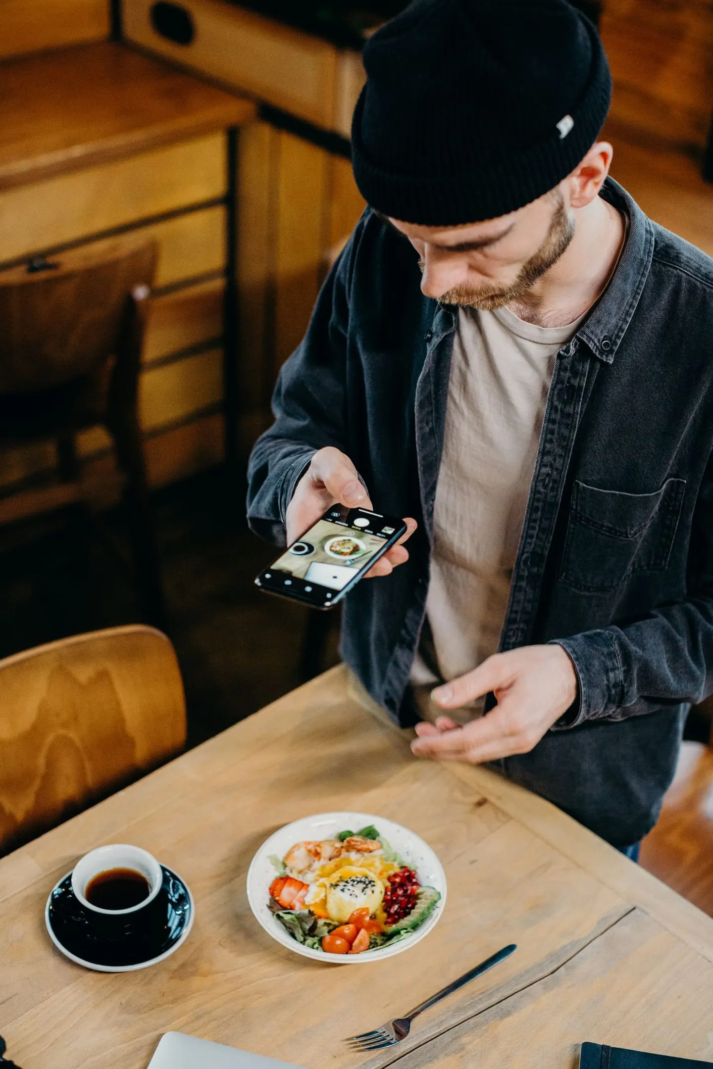 Seseorang memotret sarapan dan kopinya di atas meja