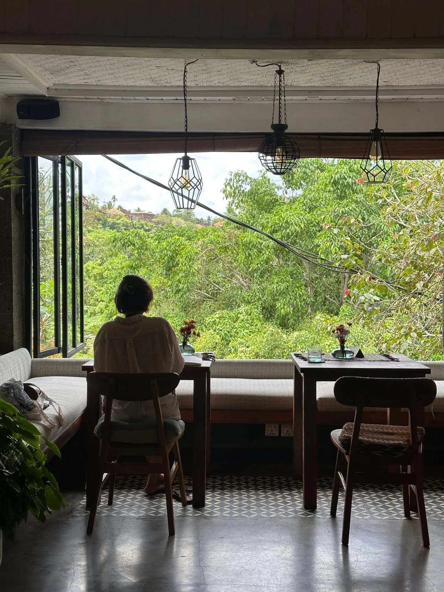 Seorang perempuan menikmati suasana kafe di Bali