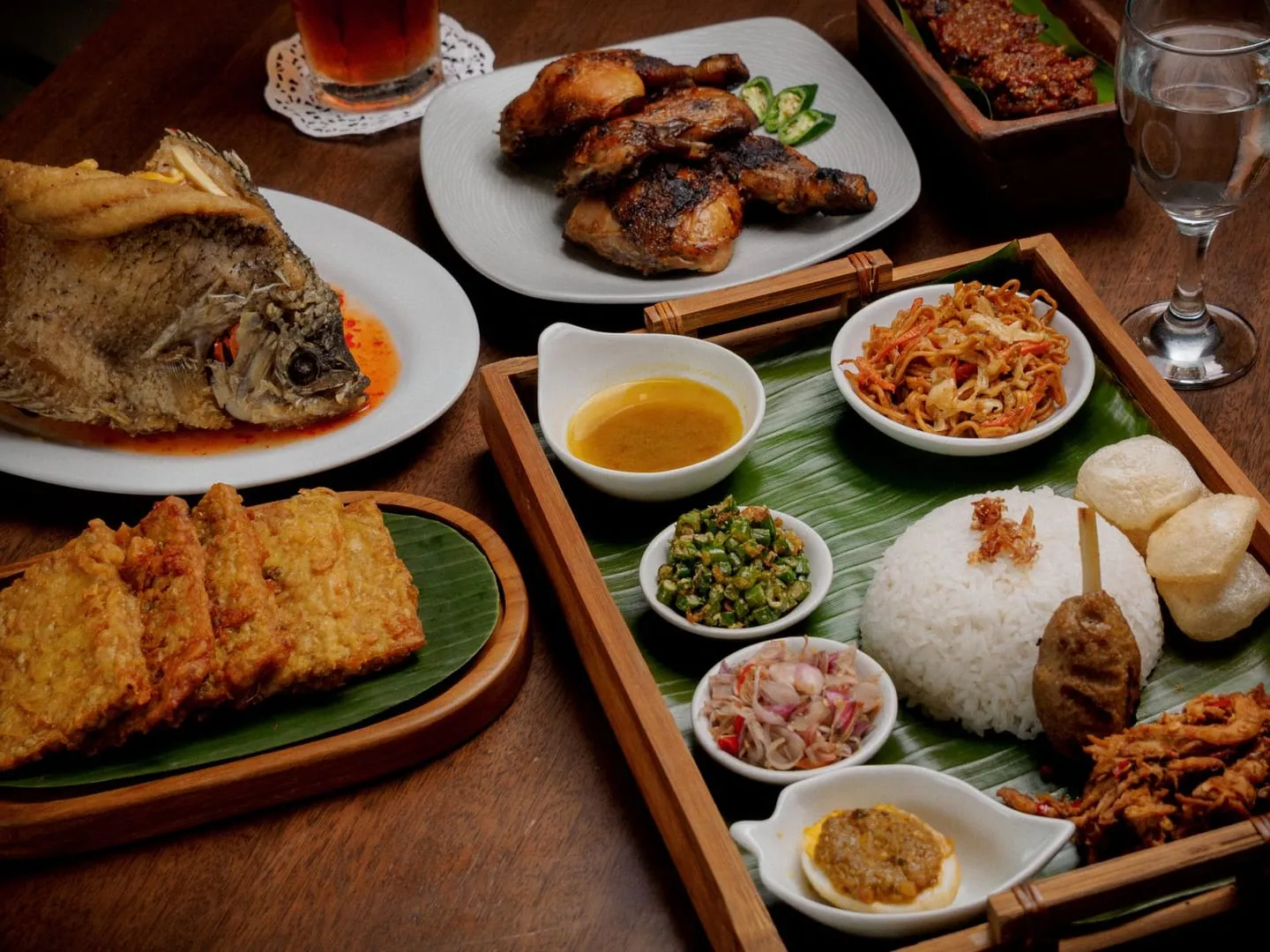 Aneka hidangan tradisional Indonesia tertata di atas meja kayu