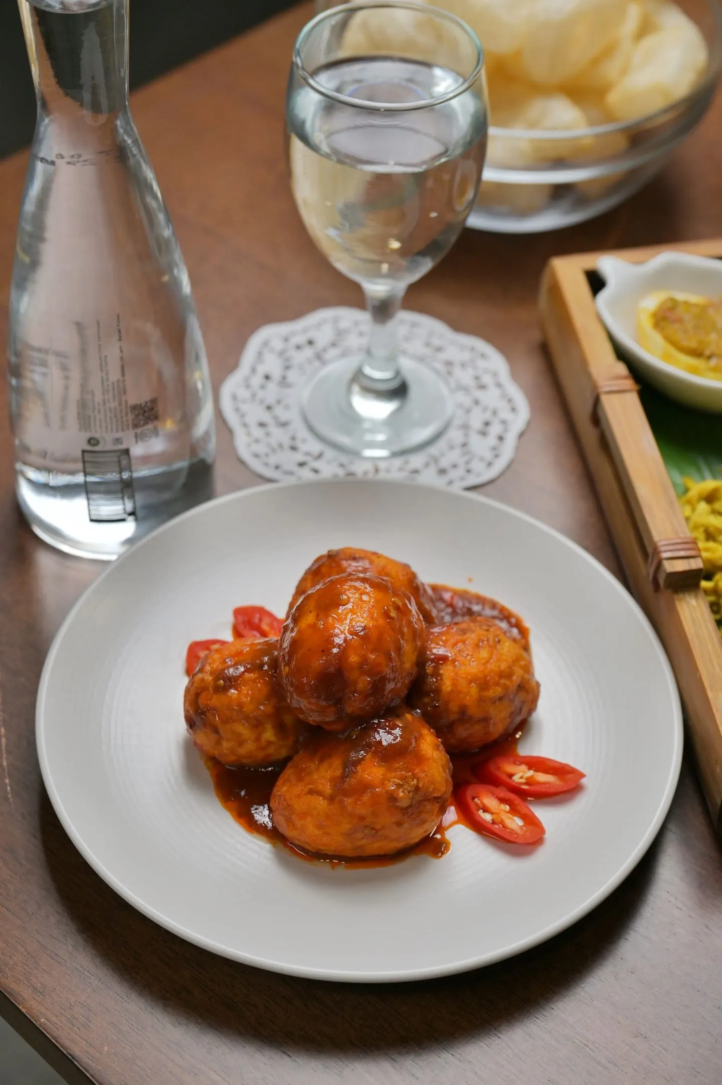 Telur balado dengan taburan cabai di atas piring putih