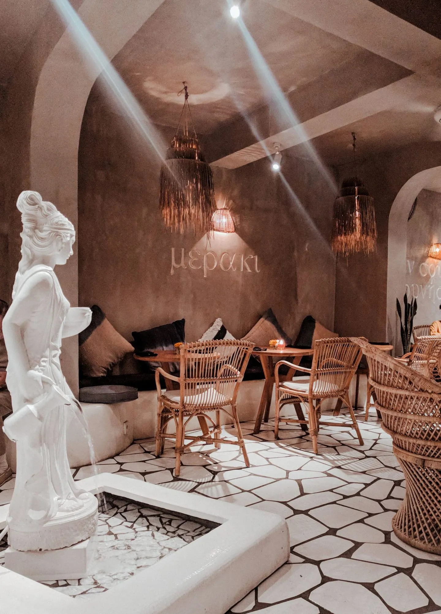 Interior kafe bergaya Bali dengan kursi kayu dan pencahayaan hangat